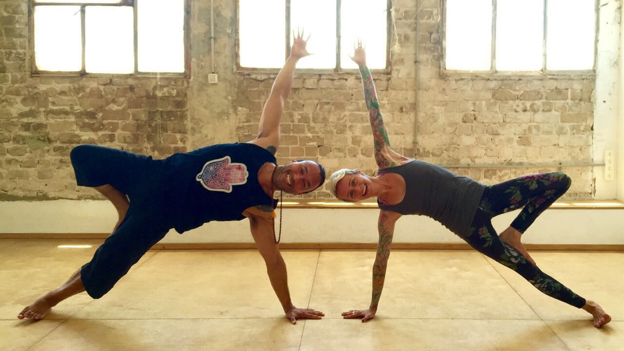 Eddy Toyonaga and Jackie displaying yoga poses for the Yoga Arava festival 2016