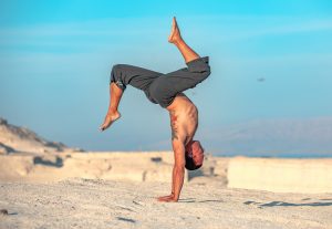 Eddy Toyonaga doing a hollowback handstand in the desert